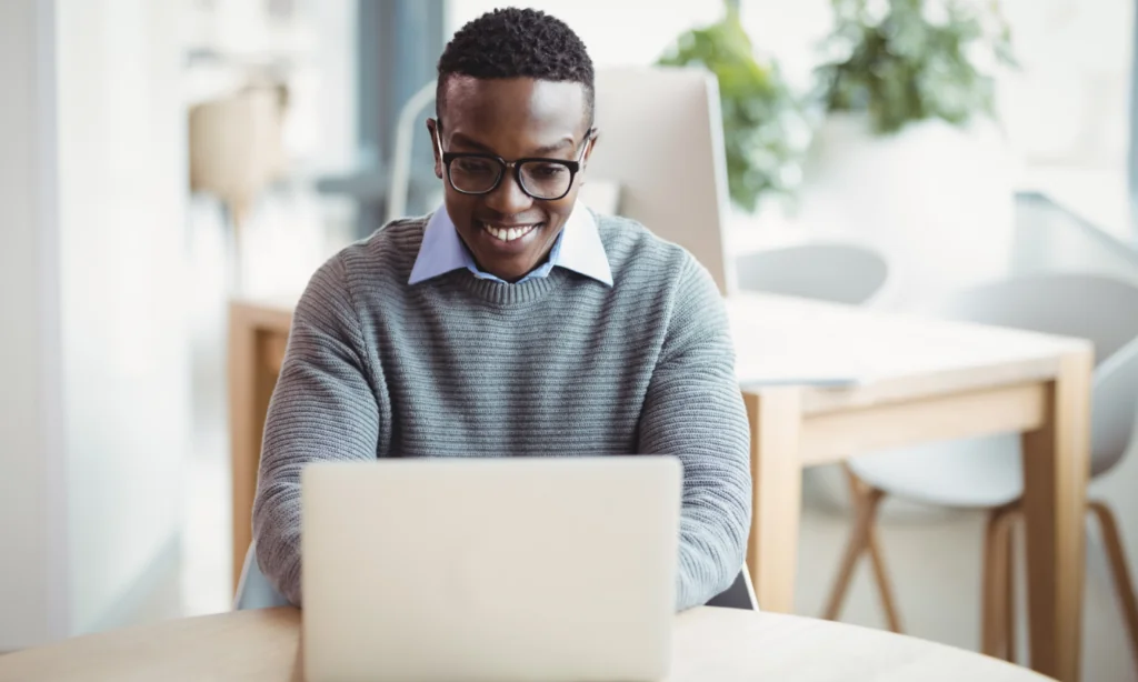 Male smiling at laptop