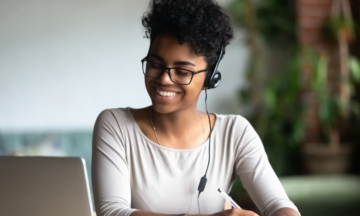 Woman smiling at laptop.