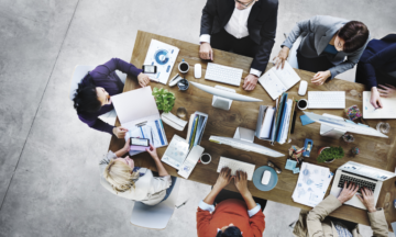 Group of people working around table.