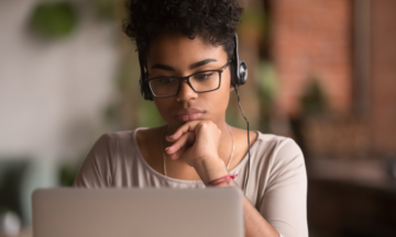 Female thinking at laptop