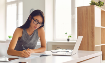 Female writing next to laptop_Blog