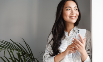 Personne tenant un téléphone et regardant au loin.